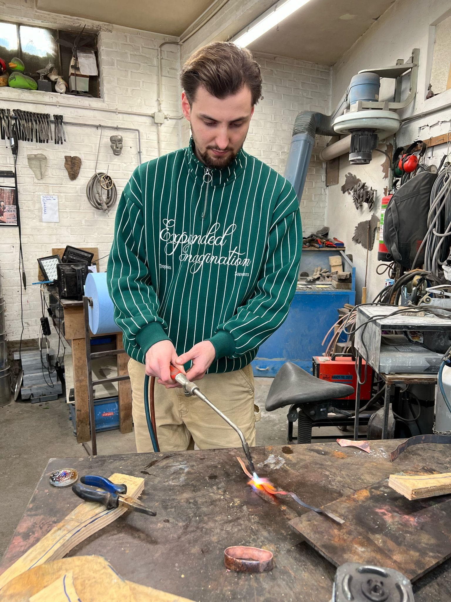 Koperdraad, hamer en gereedschap op de werkbank van het atelier